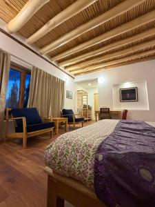 a bedroom with a bed and a living room at Nubra Ecolodge in Liekzan