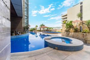a pool in the middle of a building with blue water at Crown Regency Hotel & Towers in Cebu City