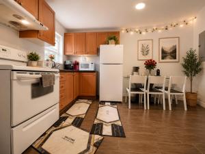 a kitchen with a refrigerator and a table with chairs at ChinaTown Boutique Rooms in Toronto