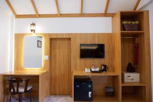 a room with a television and a desk with a table at Phi Phi Villa Resort in Phi Phi Islands