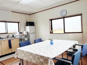 a dining room with a table and blue chairs at 田園の宿 in Takehanachō