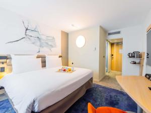 a hotel room with a large bed and a desk at Mercure Paris Massy Gare TGV in Massy +92 photos