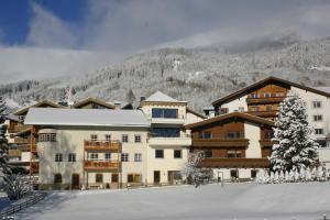 a large building in the snow in front of a mountain at An der Via Claudia Augusta in Fiss