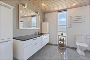 a white kitchen with a sink and a toilet at Feriehus 1120 in Ringkøbing +32 photos