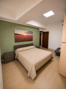 a bedroom with a bed and a painting on the wall at BluTerra home in Porto San Giorgio