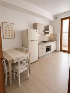 a kitchen with a table and a white refrigerator at BluTerra home in Porto San Giorgio