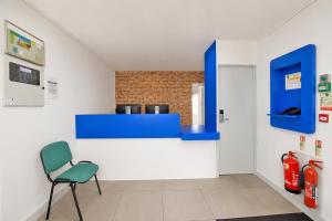 a room with a blue counter and a chair at Citi Hotel London Heathrow in Hillingdon
