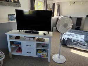 a living room with a tv and a fan at Ocean Town Homestay in Westerly