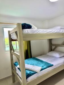 two bunk beds in a room with a window at Hostal La Marina in Santa Marta
