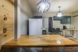 a kitchen with a table and a white refrigerator at Rustic Private Studio Near Downtown Worcester in Worcester