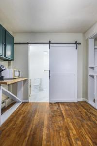 a large white door in a kitchen with wooden floors at Rustic Private Studio Near Downtown Worcester in Worcester