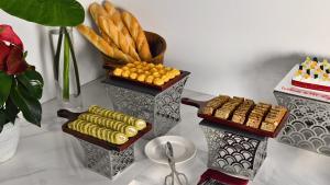 a table with two vases with corn and a plate of food at MT Collection Legacy Hotel Ninh Binh - Near Hoa Lu Ancient Town with Rooftop Pool in Ninh Binh +19 photos