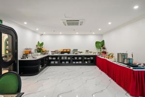 a restaurant with a counter with a red table at MT Collection Legacy Hotel Ninh Binh - Near Hoa Lu Ancient Town with Rooftop Pool in Ninh Binh