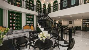 a library with a spiral staircase and tables and chairs at MT Collection Legacy Hotel Ninh Binh - Near Hoa Lu Ancient Town with Rooftop Pool in Ninh Binh