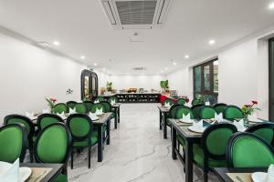 a dining room with green chairs and tables at MT Collection Legacy Hotel Ninh Binh - Near Hoa Lu Ancient Town with Rooftop Pool in Ninh Binh