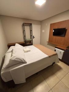 a bedroom with a large bed and a television at Blume Suítes Premium Orla in Petrolina +2 photos