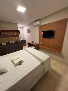 a room with a bed with a tv on a wall at Blume Suítes Premium Orla in Petrolina