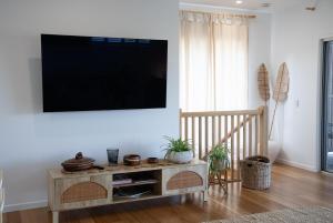 a living room with a flat screen tv on a wall at Quampi House with Best Ocean View in Point Lookout