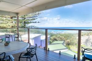 a balcony with a table and chairs and a view of the ocean at Quampi House with Best Ocean View in Point Lookout