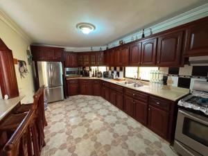a large kitchen with wooden cabinets and stainless steel appliances at Hotel1325 in Baní
