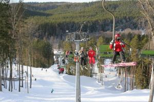 a group of people on a ski lift in the snow at Kempings Ozolkalns in Cēsis