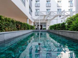 a swimming pool in front of a building at Mercure Hotel Stuttgart Airport Messe in Stuttgart