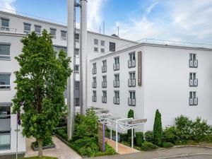 a white building with a staircase in front of it at Mercure Hotel Stuttgart Airport Messe in Stuttgart