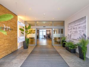 an office lobby with potted plants on the walls at Mercure Hotel Stuttgart Airport Messe in Stuttgart
