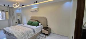 a bedroom with a bed with a green pillow on it at Charming Miramar Aparthotel in Alexandria