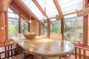 comedor con mesa de madera y ventanas en BOG Casa Ciprés, en Villa La Angostura 26 fotos más