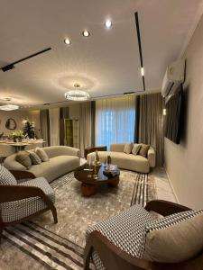 a living room with two couches and a table at Charming Miramar Aparthotel in Alexandria