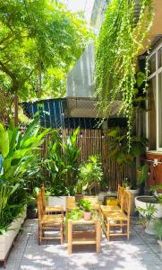 a patio with a table and chairs and plants at Ni Nớ Home in Hue