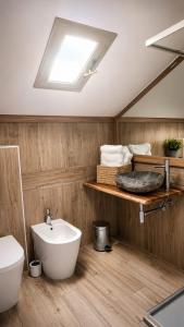 a bathroom with a sink and a toilet and a skylight at mansarda roulette in Saint Vincent +15 photos