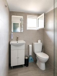 a bathroom with a toilet and a sink and a mirror at Paradox Cantacuzino in Eforie Sud +19 photos