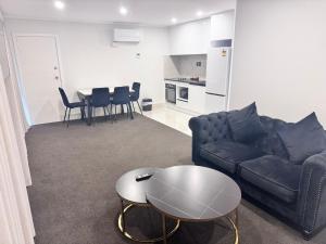 a living room with a couch and a table at Manukau Hotel & Conference Centre in Auckland