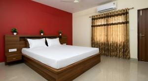 a bedroom with a bed and a red wall at Lagna Mahal in Birnon