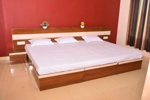 a bed with white sheets and pillows in a room at Lagna Mahal in Birnon