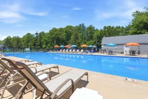 a large swimming pool with lounge chairs and umbrellas at Chalet 71 in Stevensville