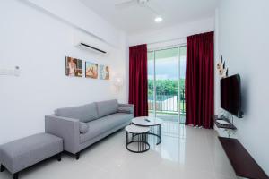 a living room with a couch and a tv at Trival Property Homestay Sri Indah Sandakan in Sandakan