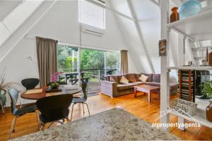 a living room with a table and chairs at The A-Frame in Halls Gap