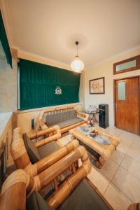 a living room with wooden furniture and a green chalkboard at New Puri Asih Hotel in Kuta
