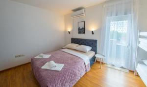 a bedroom with a bed with two towels on it at DalEro Sunset Apartments Medjugorje in Međugorje