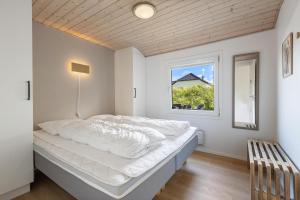 a bed in a room with a window at Feriehus 1120 in Ringkøbing