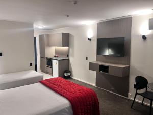 a hotel room with two beds and a flat screen tv at Manukau Hotel & Conference Centre in Auckland +18 photos