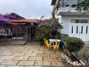 a patio with two chairs and a table in front of a house at Mây inn' Cầu Đất - Homestay in Xuân Trường