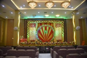 a stage in a hall with chairs and a screen at Lagna Mahal in Birnon
