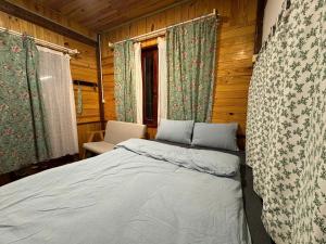 a bedroom with a bed in a wooden room at Mây inn' Cầu Đất - Homestay in Xuân Trường