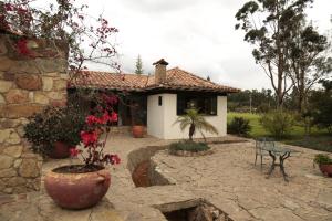 a house with a patio and a table in front of it at Finca Villa Sofía in Villa de Leyva