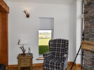 a living room with a chair and a window at Ryka Lodge in Back