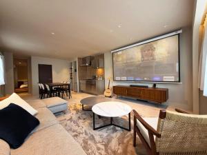 a living room with a large flat screen tv at TABISAI HOTEL Premium 博多-中洲 in Fukuoka +37 photos